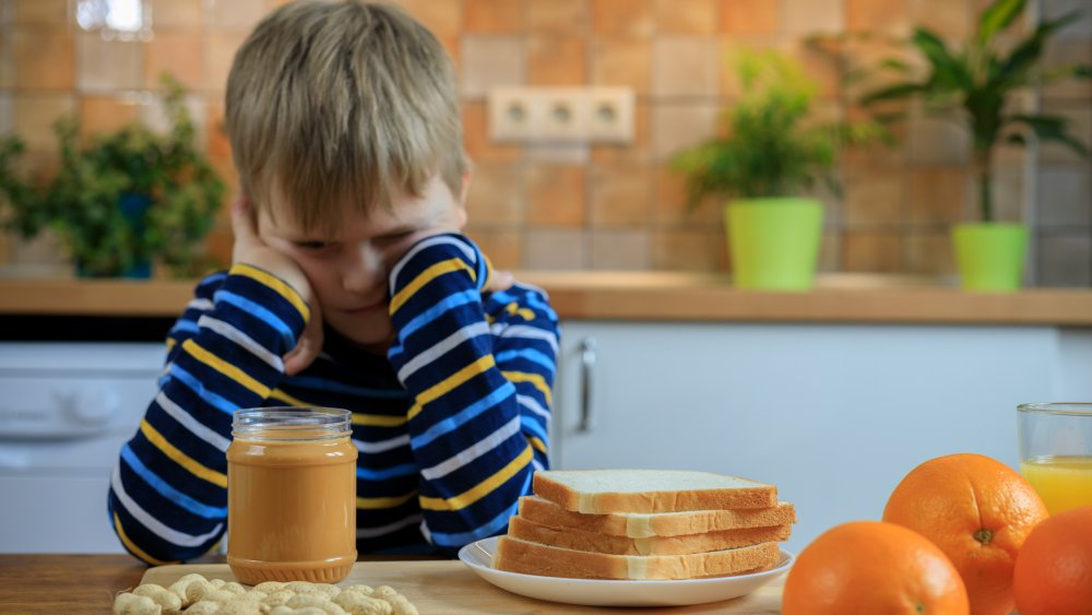 Unhappy kid with peanut butter sandwich