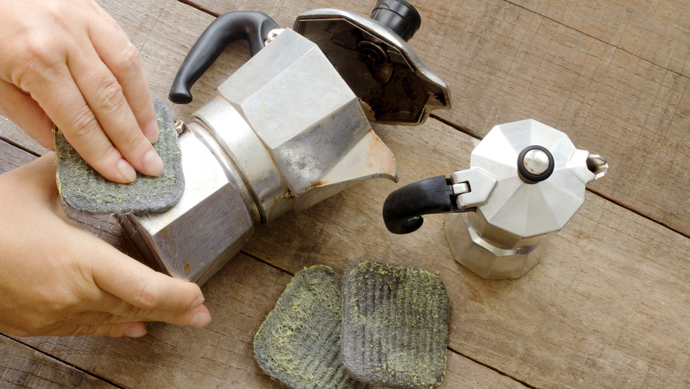 Person scrubbing espresso maker