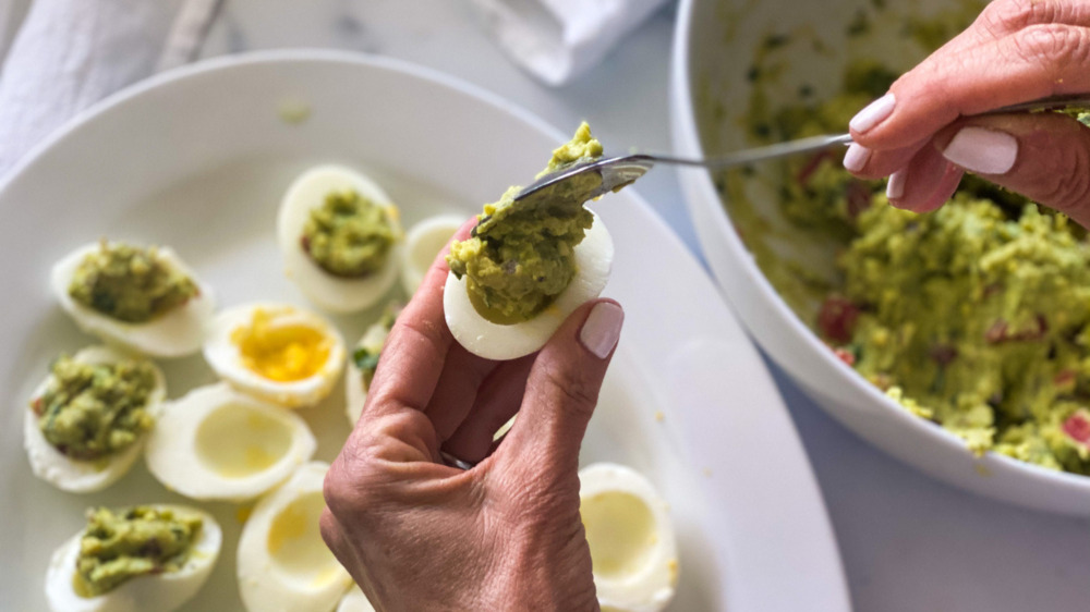 filling deviled eggs with guacamole