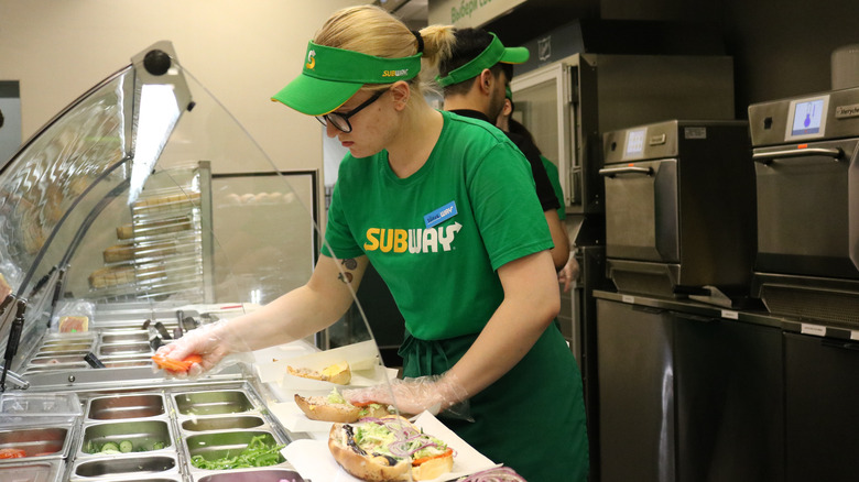 Subway employee making sandwiches