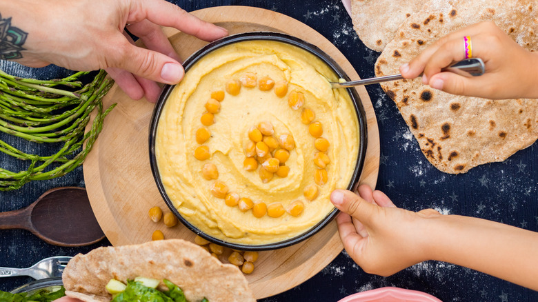 big platter of hummus in the middle of a table