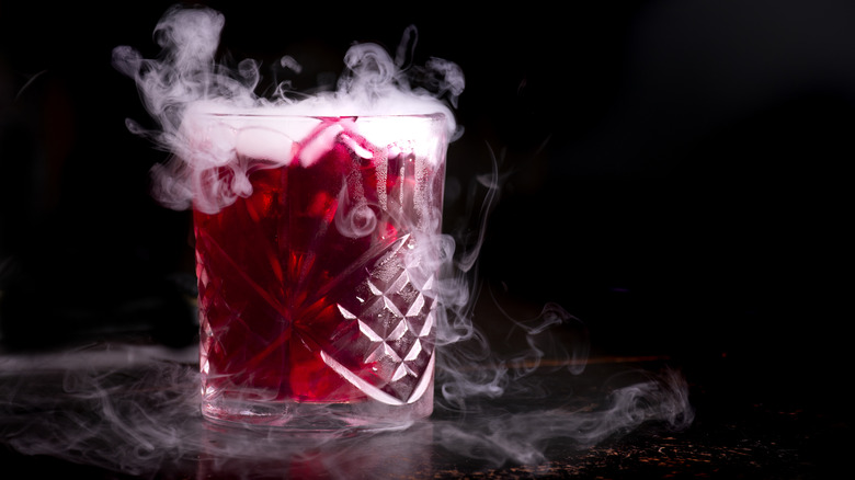 Red cocktail with dry ice