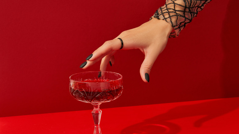 Hand reaching for red cocktail