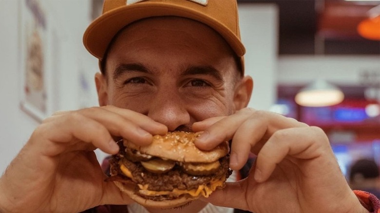 man eating Five Guys burger