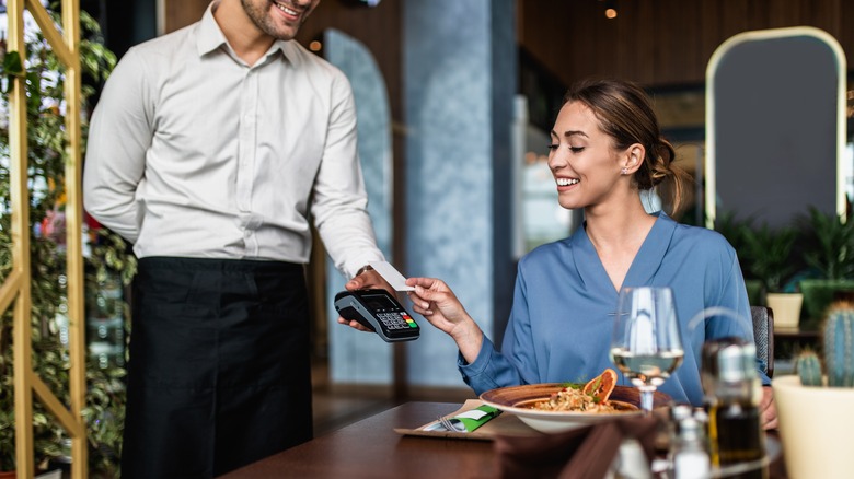 person tapping credit card machine