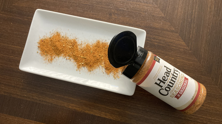 A shaker pouring out Head Country barbecue seasoning on a dish