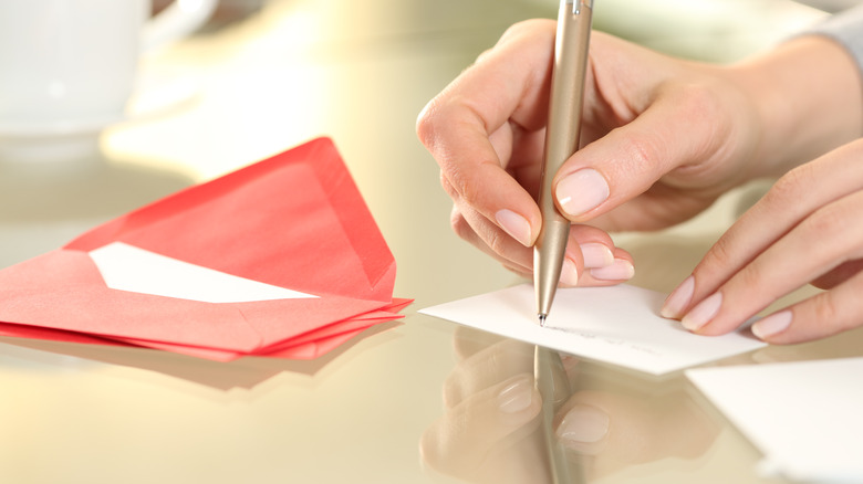 A person writing a thank you note