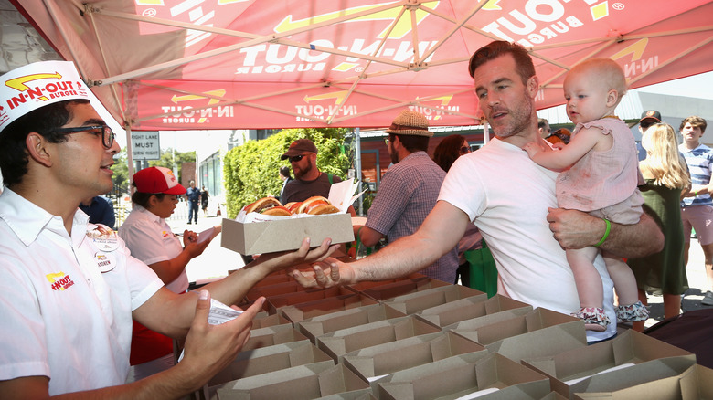 In-N-Out employee handing burgers to man with baby