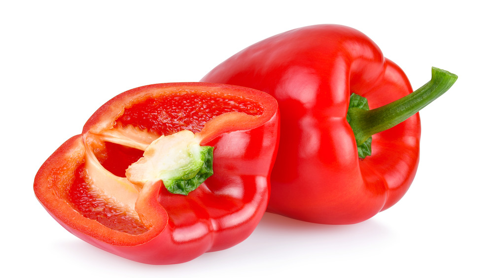 cut and whole red bell pepper on white background