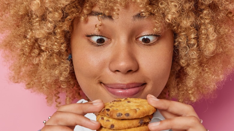 curly haired girl with stack of cookies