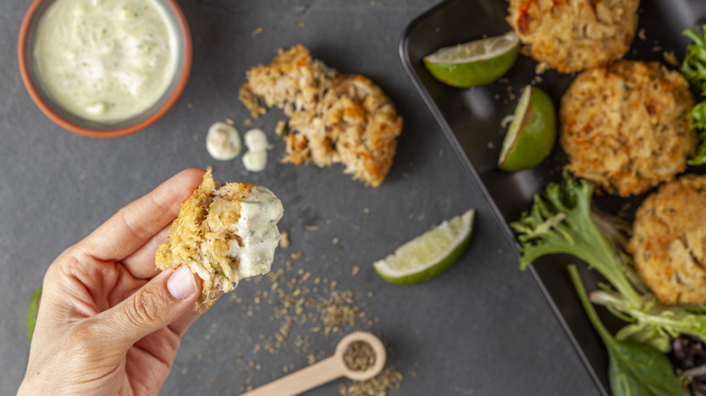 hand holding dipped maryland crab cake