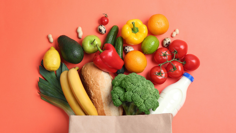 Colorful vegetables and milk carton on orange background