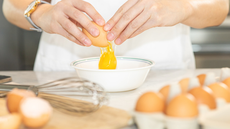 Cracking eggs into mixing bowl