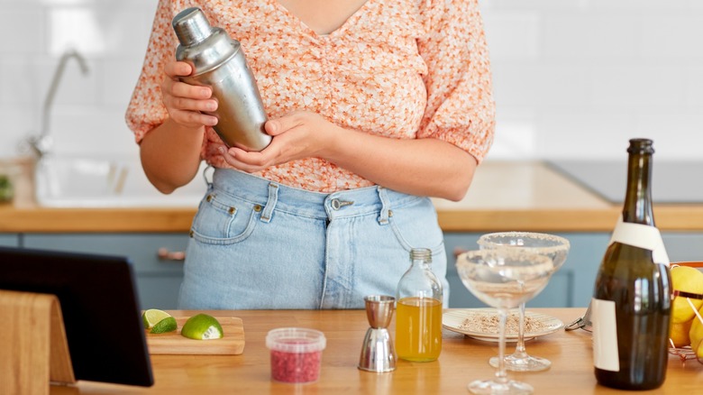 Person holding cocktail shaker