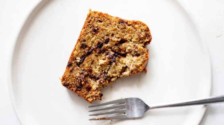 A slice of banana bread on a plate with a fork