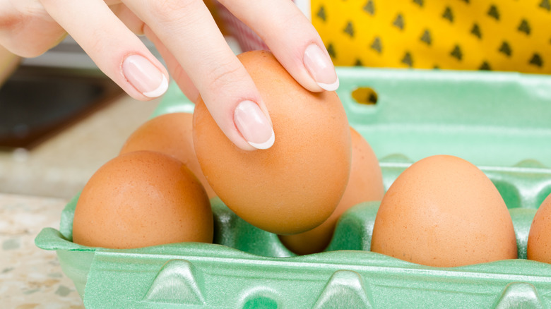 person removes egg from carton