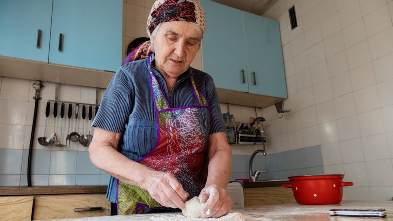 grandmother kneading dough in the kitchen