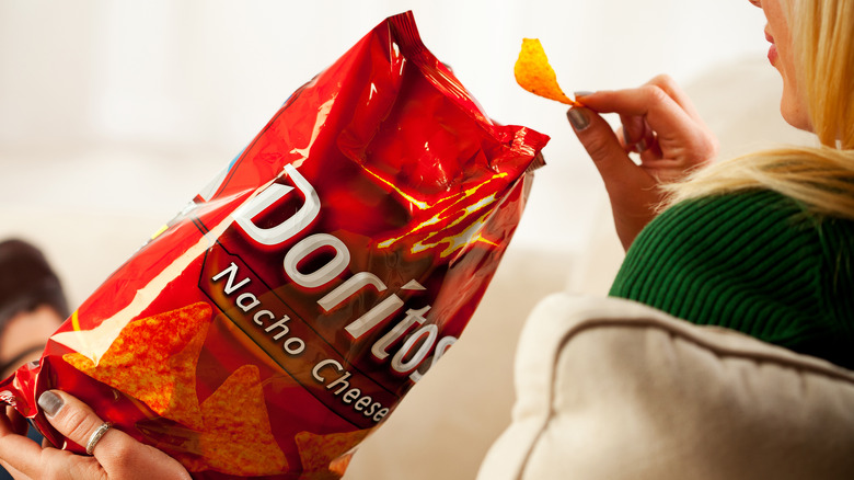 A woman enjoying Doritos chips