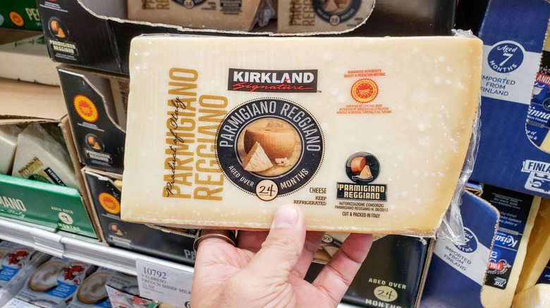 Hand holding a wedge of Kirkland Signature Parmigiano-Reggiano