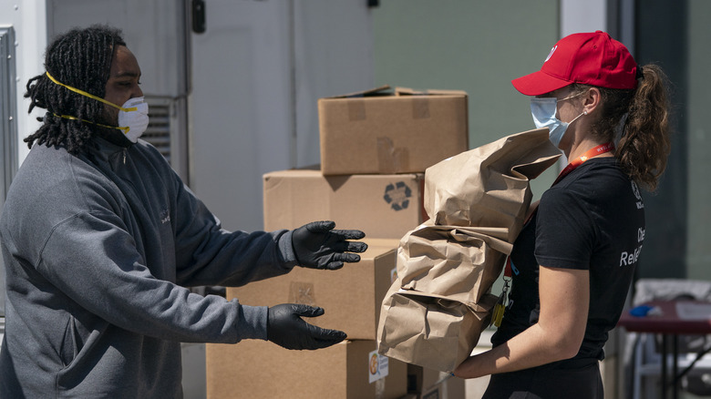 world central kitchen employee handing out meals