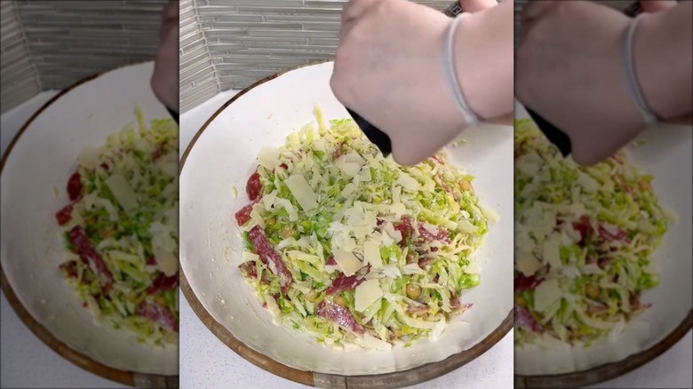 hand grinding pepper into salad