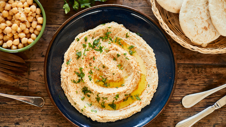 hummus with olive oil and herbs on a plate