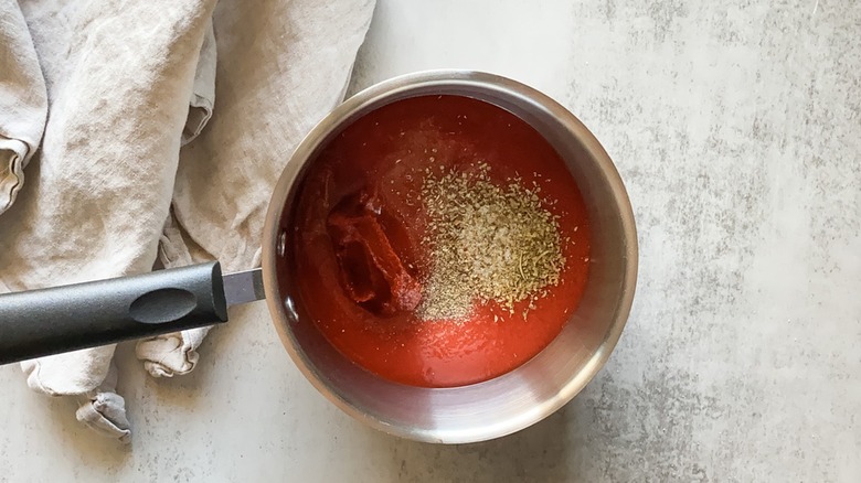 Tomato sauce, tomato paste, and seasonings in a saucepan