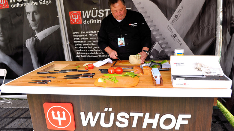 A man demonstrating Wüsthof knives on a countertop