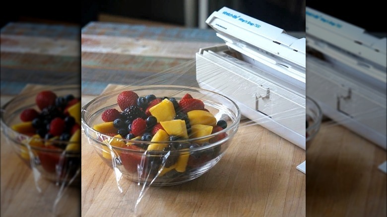 Bowl of fruit covered in plastic wrap