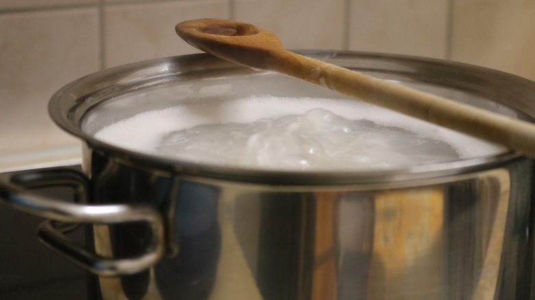 wooden spoon balancing on a pot of boiling water