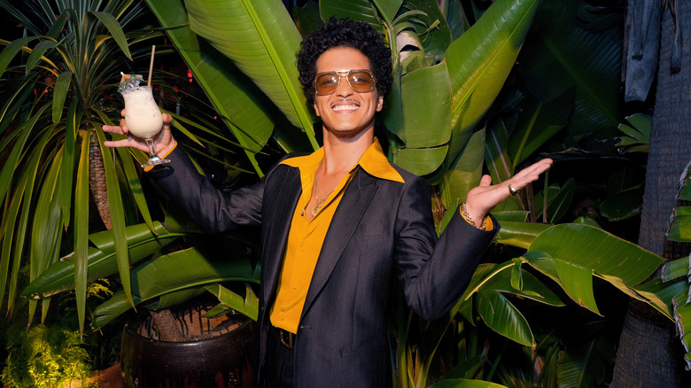 Bruno Mars smiling with drink