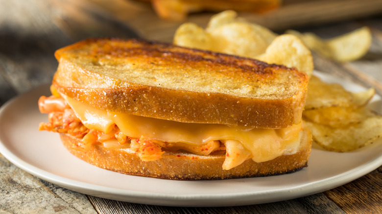 kimchi grilled cheese sandwich on plate with chips