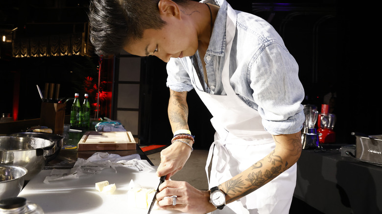 Kristen Kish slicing food ingredient