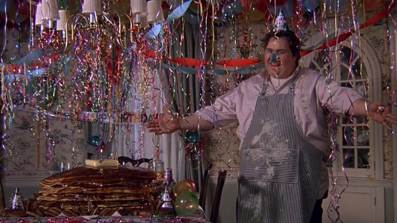 Scene from Uncle Buck with Uncle Buck, a stack of giant pancakes, and birthday decorations