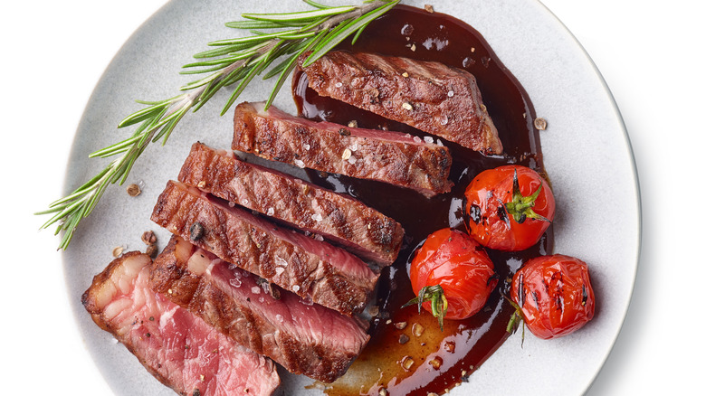 Sliced beef with tomatoes on a plate 