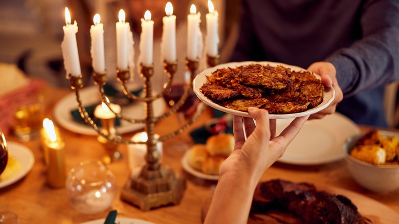 People passing latkes at Hanukkah dinner