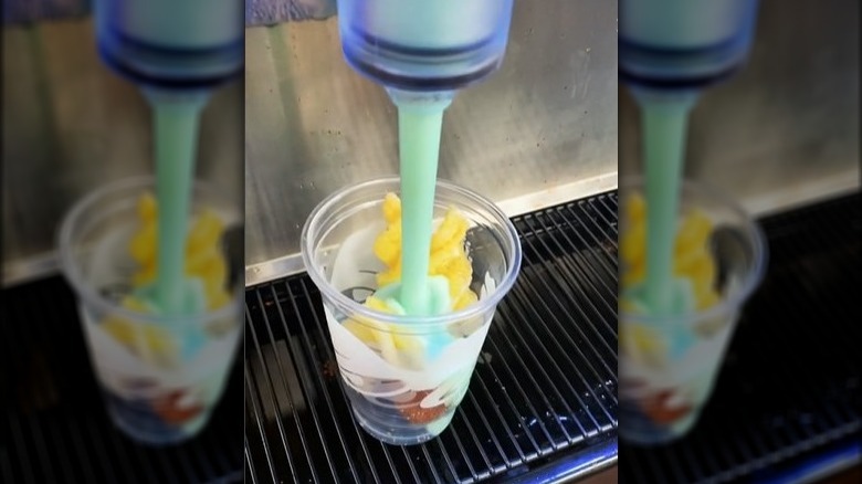 TikTok user @caleb_lennon's pouring Baja Blast Freeze into a cup of cinnamon twists and Cinnabon Delights at Taco Bell.