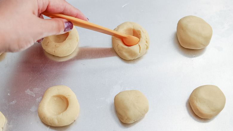 Hand making thumbprint cookies