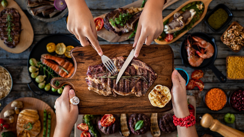 Hands reaching over a table feast