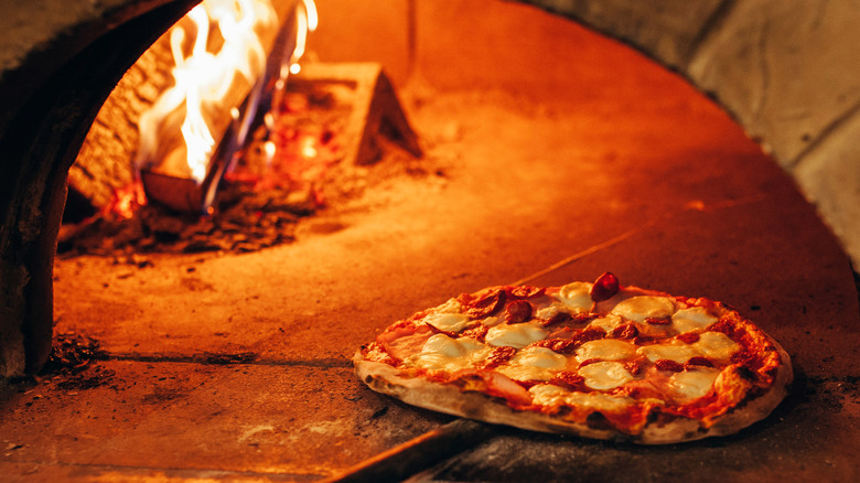 Pizza cooking in wood brick oven.