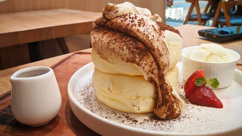 A stack of souffle pancakes with cream and ice cream