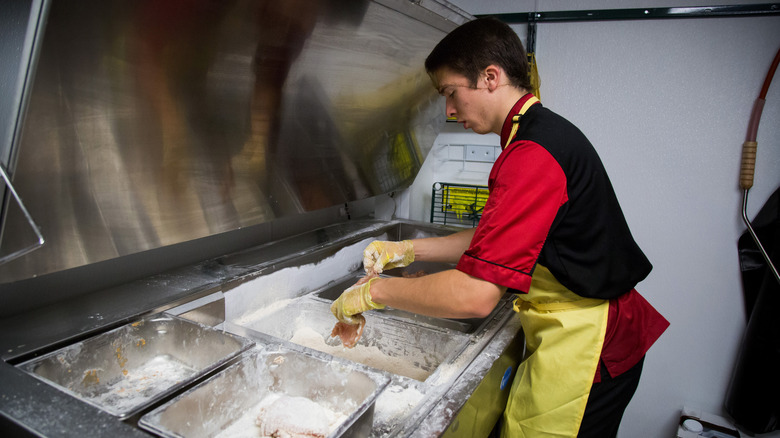 Chick-fil-A employee breadking chicken