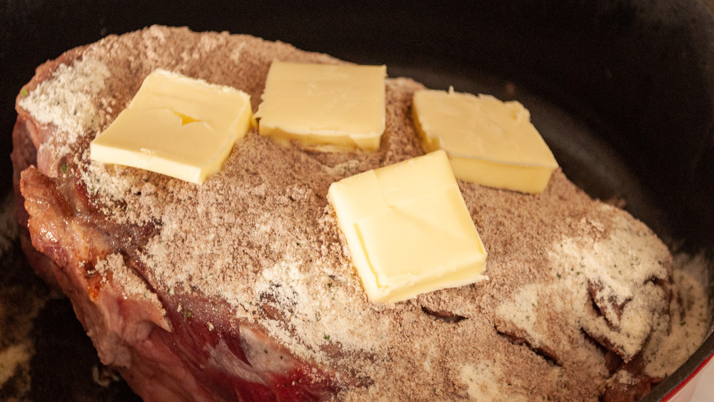 pats of butter on top of roast in slow cooker