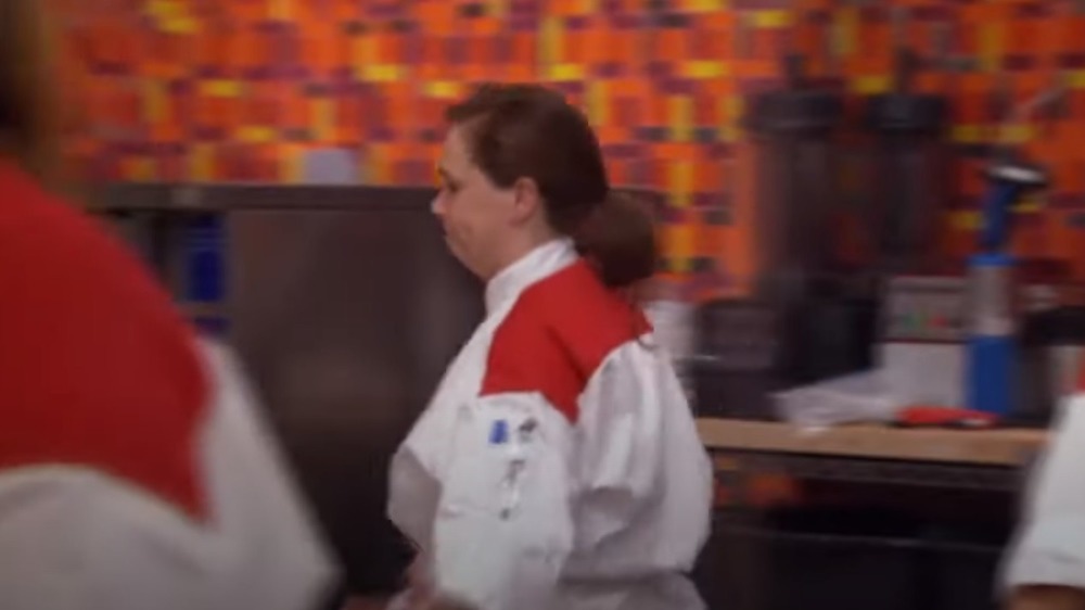 Woman in chef's coat walking off Hell's Kitchen set