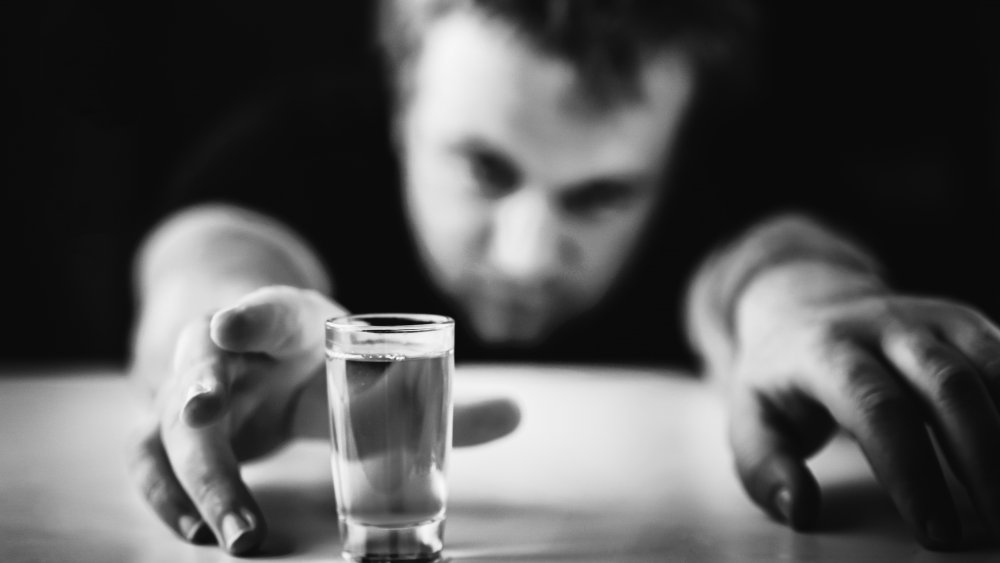 Drunk man reaching for shot food challenge