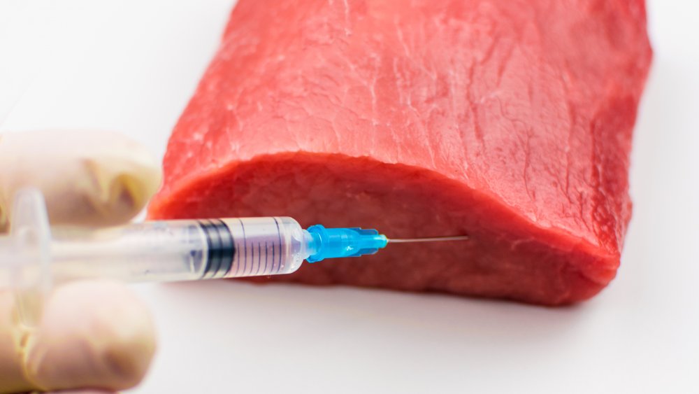 Meat being injected with a needle