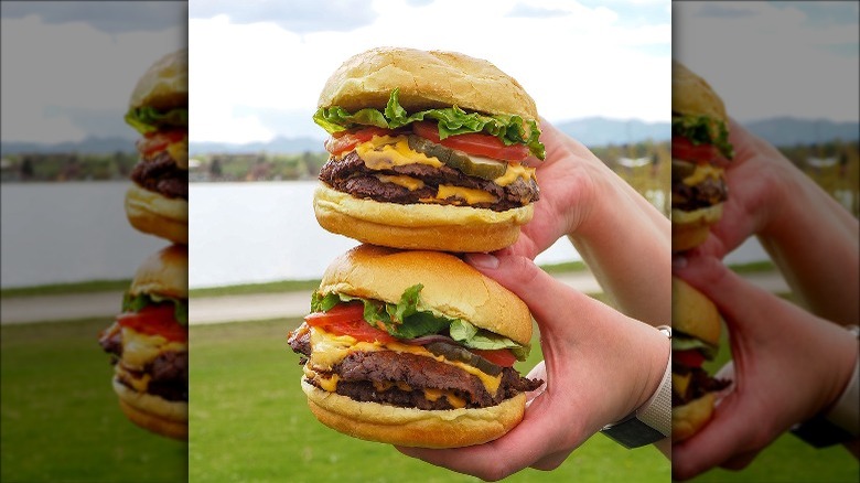 Person holding two smashburgers