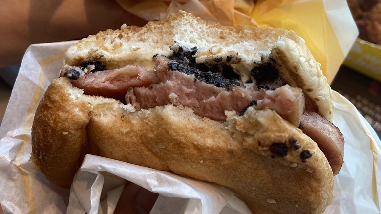 Half-eaten Oreo Spam burger in hand