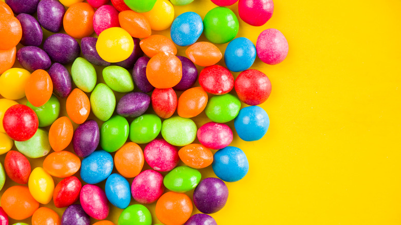 Skittles against a yellow background 