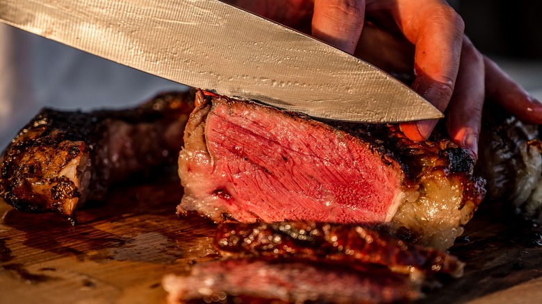 cutting into a cooked sirloin steak